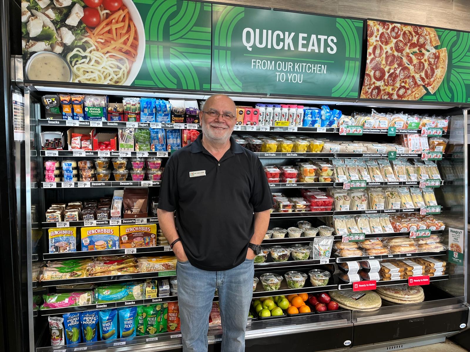 Sam standing in front of the Quick Eats fresh food cooler.